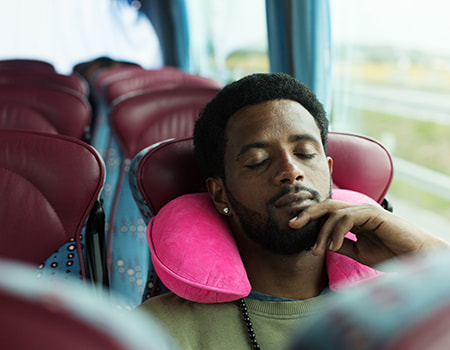 A bus passenger naps on a charter bus rental